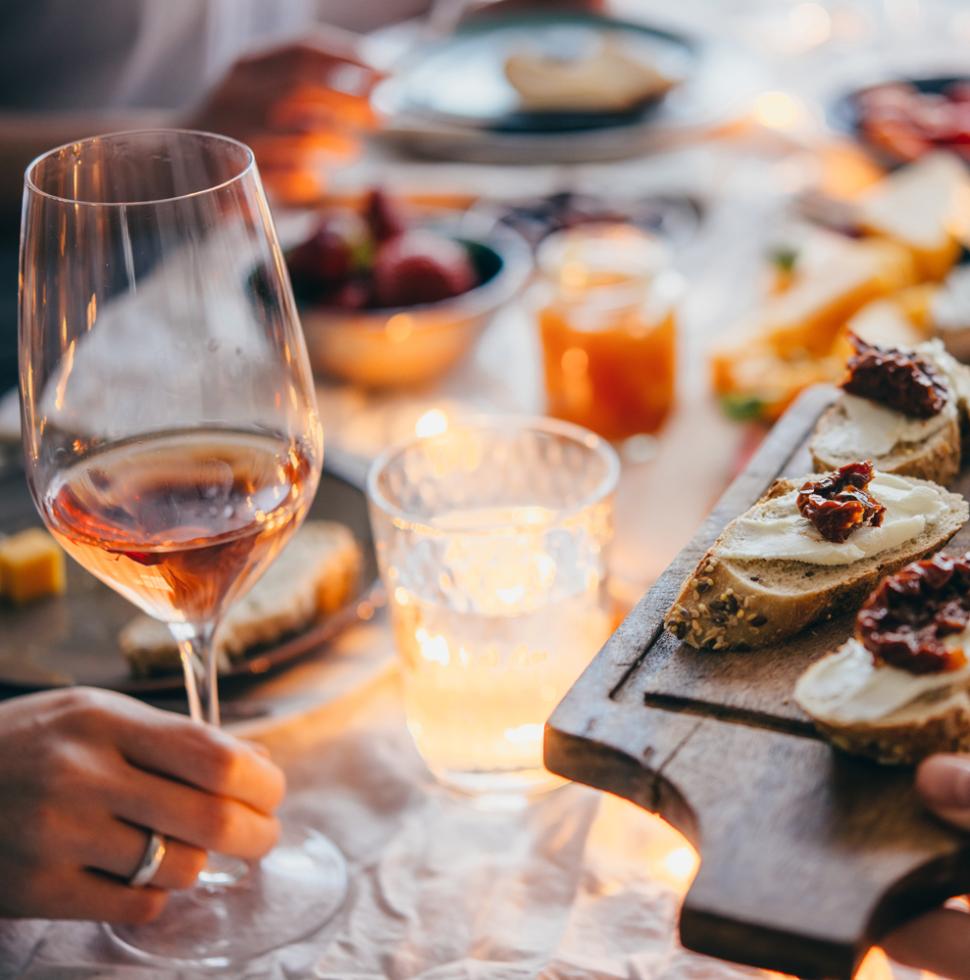 Cena intima: bruschette, vino e luci soffuse creano un'atmosfera calda e accogliente.